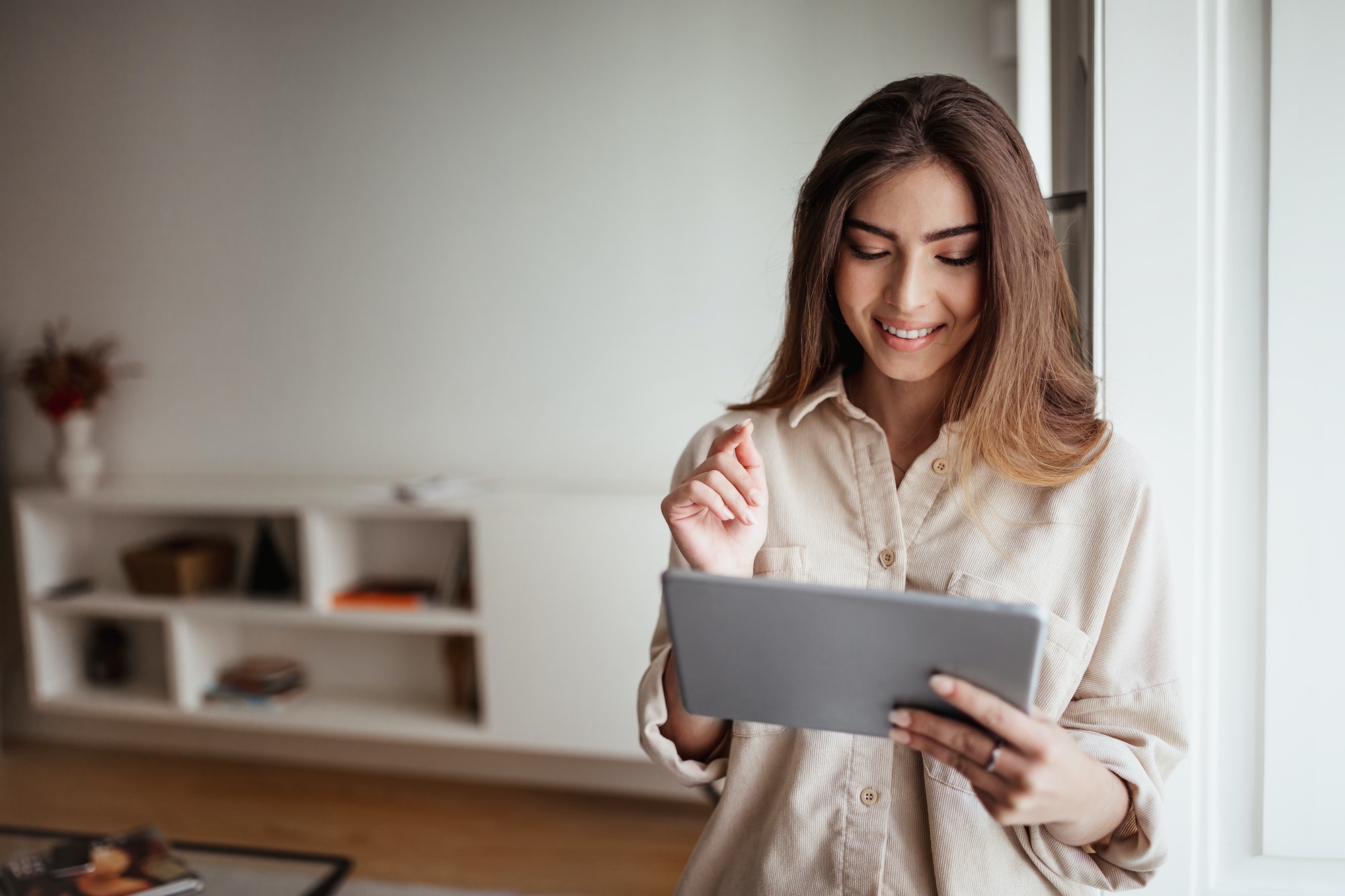 smiling-pretty-young-asian-lady-in-casual-use-tablet-for-control-smart-home-enjoy-study-and-work.jpg